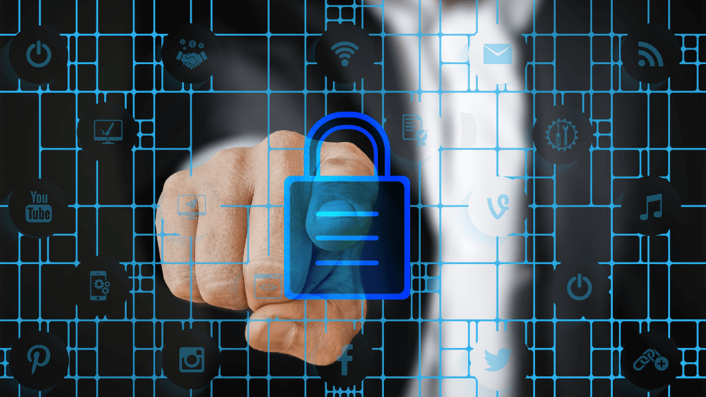 Hand pointing through digital security lock icon, surrounded by technology symbols, representing cybersecurity.
